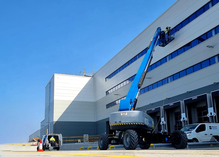 Industrial cleaning team carrying out window washing services outside a big building